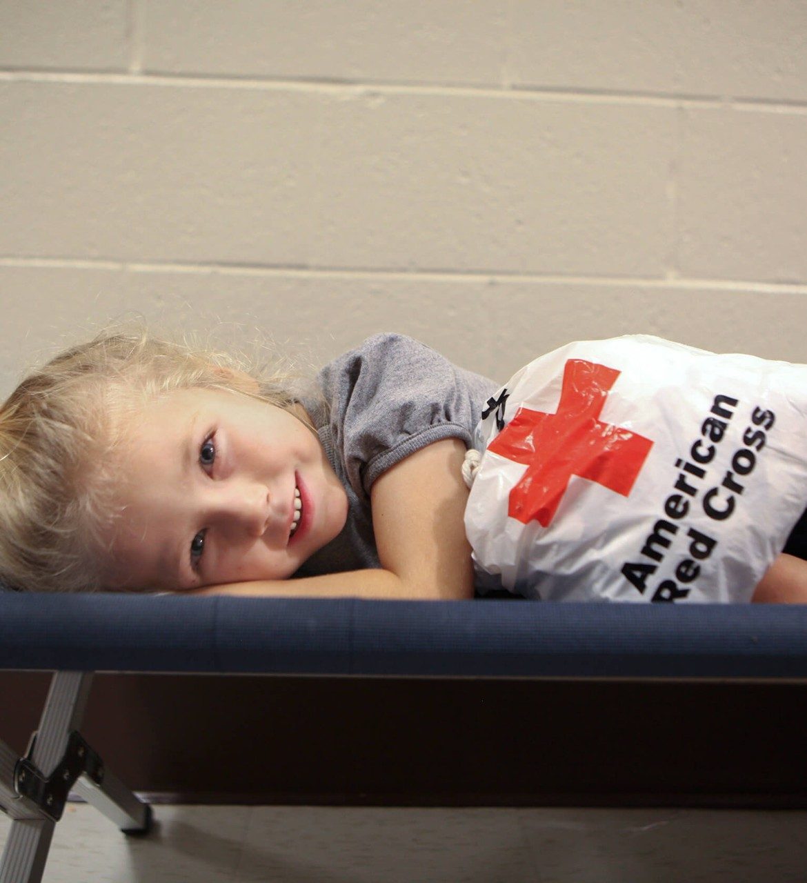 little girl on cot in shelter
