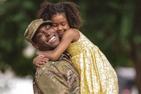 Man in military uniform holding his daughter