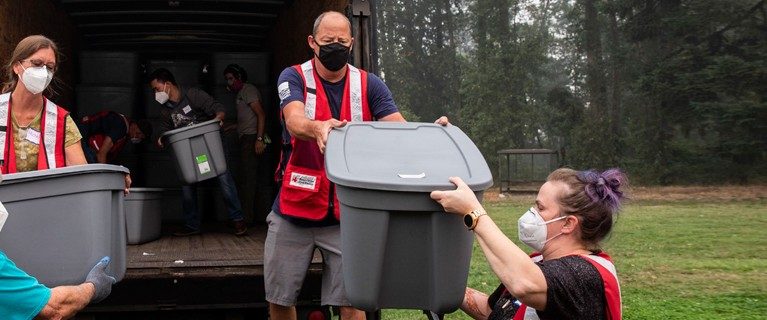 Red Cross volunteer helping load a truck
