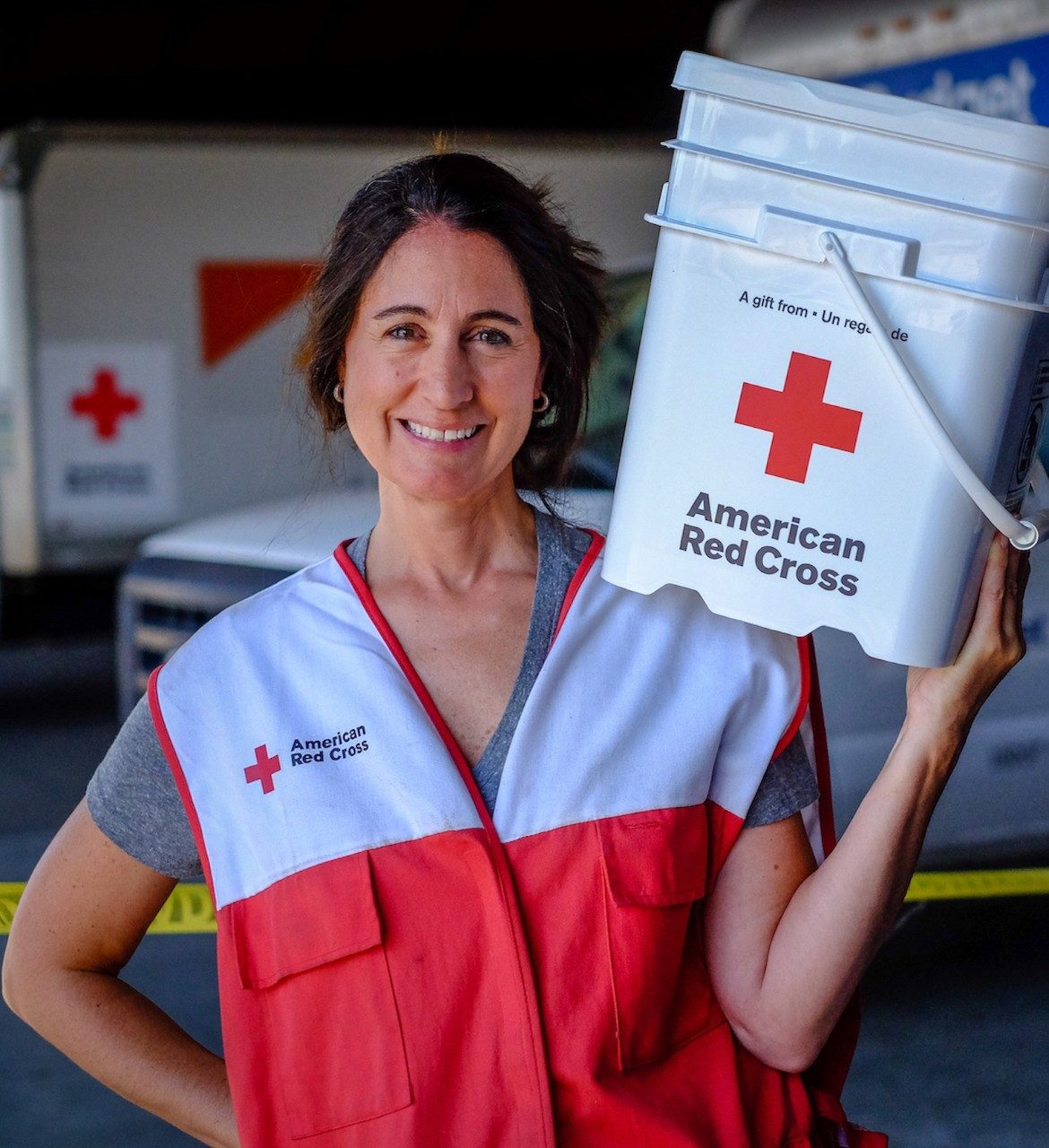 Red Cross volunteer holding a bucket full of supplies
